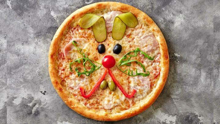En pizza med ett kaninansikte gjort av gr&ouml;nsaker.