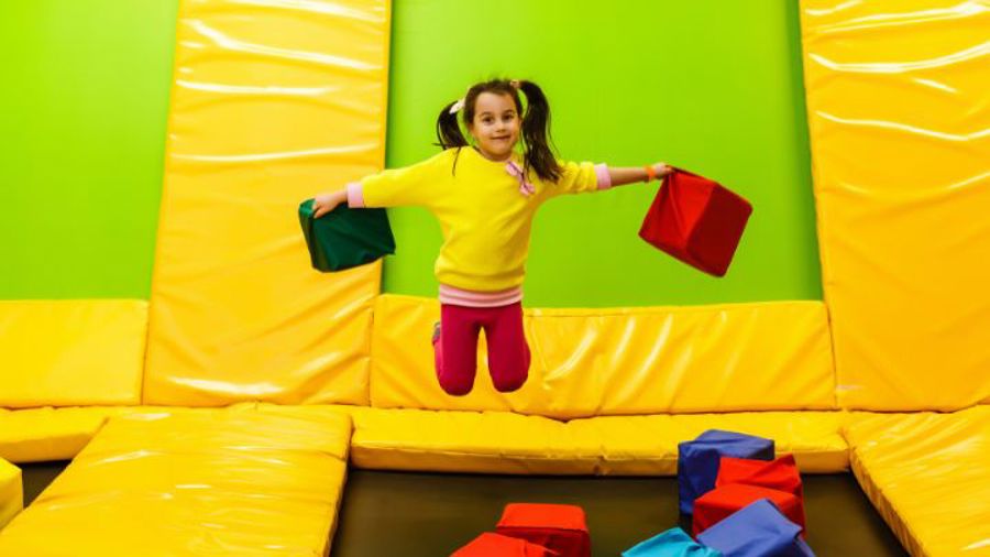 Flicka som hoppar i trampolinpark