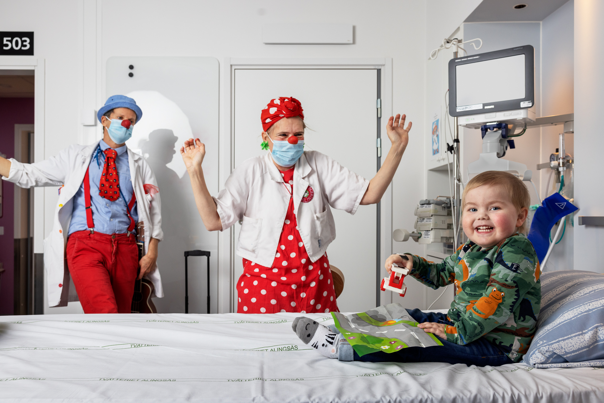 Två clowner som besöker ett sjukt barn på sjukhuset