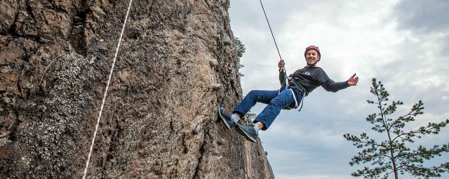 Pojke klättrar på bergsvägg